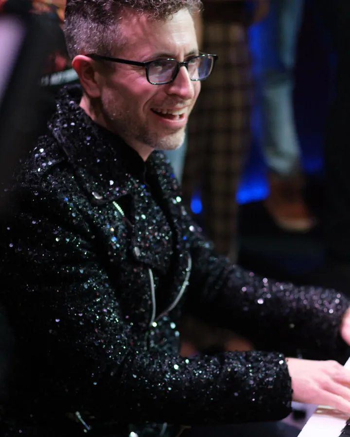 Greg Spero smiling at the keyboard during a show